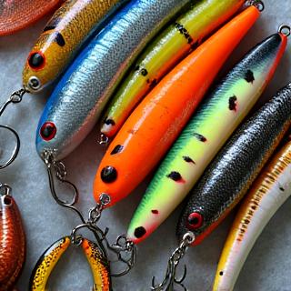 Colorful assortment of crankbaits, soft plastics, and spoons in a tackle box.