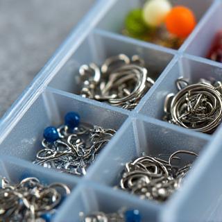 Small containers filled with hooks, swivels, and sinkers, meticulously organized.
